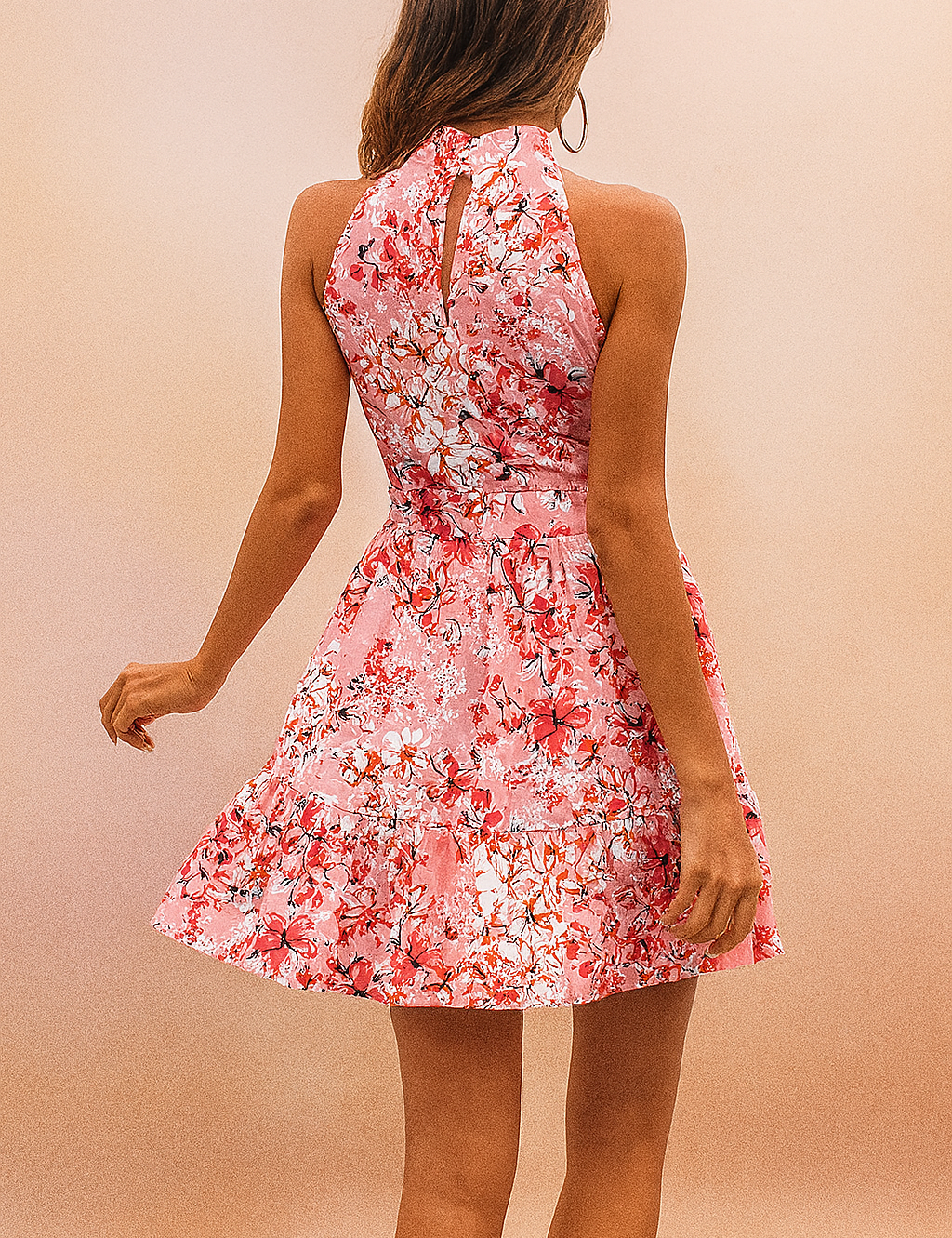 Mouwloze roze mini-jurk met bloemenprint en hoge hals, geschikt voor casual of strandoutfits
